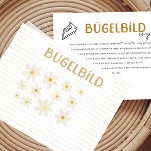 Könnte beinhalten: Eine weiße Karte mit einem gelben Gänseblümchenmuster und Anweisungen zum Aufbügeln eines Designs. Die Karte lautet "Bügelbild so geht's" und enthält Schritte zum Aufbügeln eines Designs.