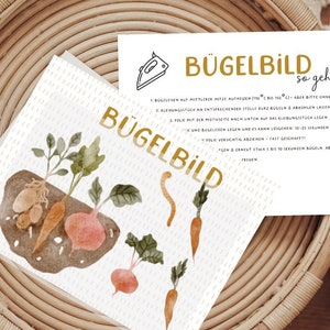 Könnte beinhalten: Ein Set Bügelbilder mit einer Aquarell-Illustration von Gemüse, darunter Karotten, Kartoffeln und Rote Bete. Die Bügelbilder sind mit "Bügelbild" in goldenen Buchstaben beschriftet. Anweisungen zum Aufbügeln der Bilder sind auf der Karte enthalten.