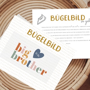 Könnte beinhalten: Eine weiße Karte mit dem Text "big brother to be" in bunten Buchstaben. Die Karte liegt auf einem geflochtenen Korb mit einer zweiten Karte, auf der "Bügelbild so geht's" steht, mit Anweisungen zum Aufbügeln des Designs.