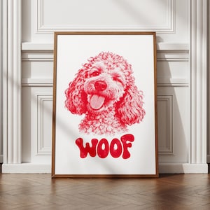 Könnte beinhalten: Ein gerahmter Kunstdruck mit einer detaillierten roten Tuschezeichnung eines lockigen Hundes, der zwinkert und die Zunge herausstreckt. Unter dem Hund ist das Wort WOOF in einer fetten, abgerundeten roten Schriftart auf das weiße Papier gedruckt.
