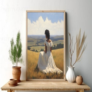 May include: A framed painting depicting a woman in a white dress seated in a field. The woman is gazing out at a rolling green landscape. The sky is blue with white clouds.