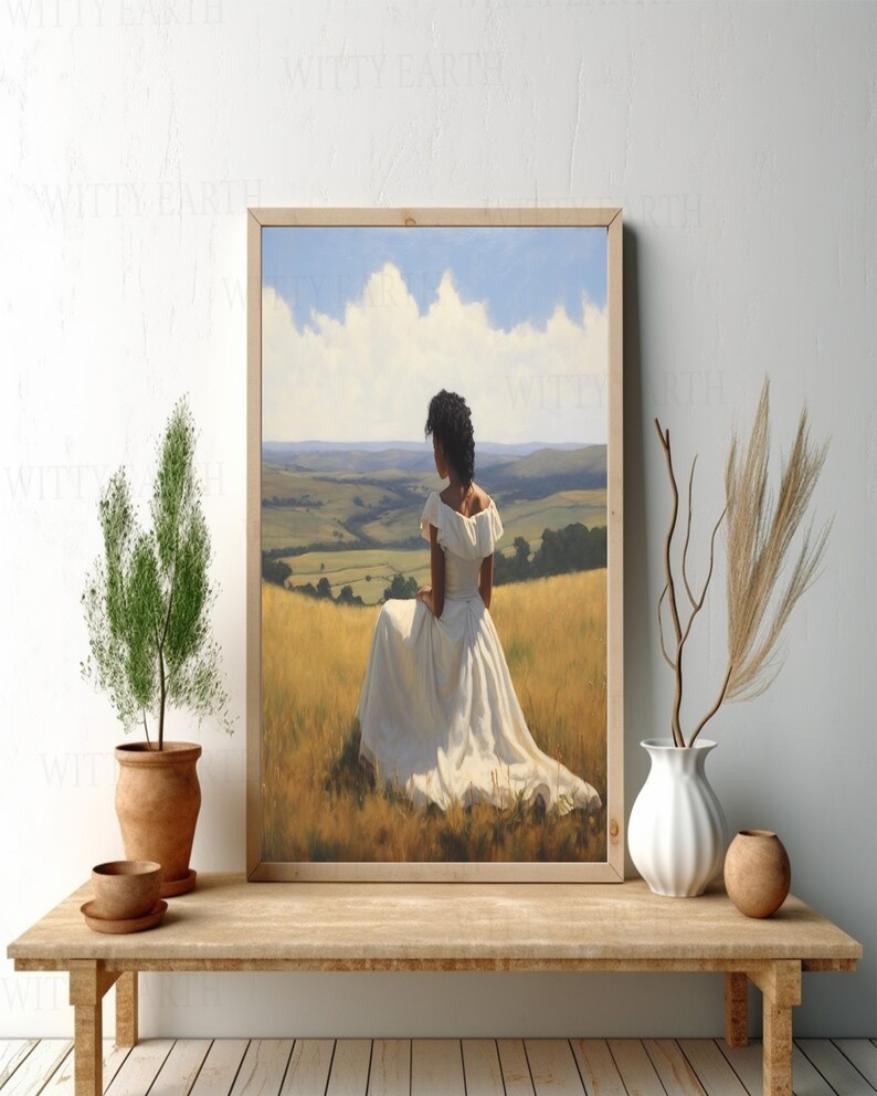 May include: A framed painting depicting a woman in a white dress seated in a field. The woman is gazing out at a rolling green landscape. The sky is blue with white clouds.