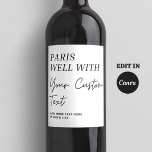 以下が含まれることがあります： 白いワインボトルのラベルに、黒い文字で「Paris Well With Your Custom Text」と「Add More Text Here If You'd Like.」と書かれています。ラベルには、白い文字で「Edit In Canva」と書かれた黒い円も含まれています。
