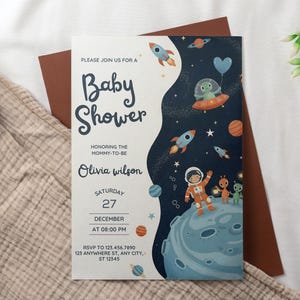 May include: Baby shower invitation with an outer space theme. The invitation features rockets, planets, and an astronaut with aliens. The text reads "Baby Shower" and includes the date, time, and RSVP information.