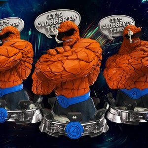 Peut inclure: Trois bustes en orange et gris de La Chose de la série de bandes dessinées Fantastic Four. Chaque statue a une bulle de dialogue au-dessus de sa tête qui dit "C'est l'heure de la baston !"
