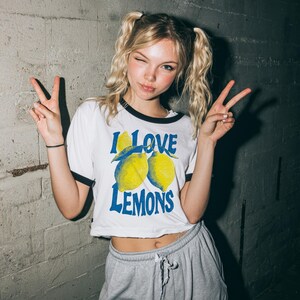 I Love Lemons t-shirt design featuring three hand-drawn yellow lemons with blue shading and bold retro blue text that says “I LOVE LEMONS.” A vibrant summer fruit graphic perfect for sublimation, printable t-shirts, summer merch, lemon-themed gifts, or wall art. Includes high-resolution PNG and PDF files for instant download. Ideal for fruit lovers, bold fashion, and sunny summer apparel. Gift for Her, gift for him.