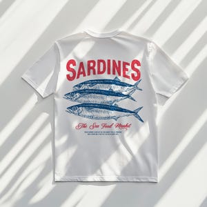 Vintage sardines illustration digital design featuring three detailed sardines with classic typography, perfect for t-shirts, mugs, wall art, kitchen decor, tote bags, and coastal home accessories. Includes 1 high-resolution PNG file with transparent background and 1 PDF file. Ideal for seafood lovers, nautical themes, ocean-inspired decor, and creative DIY projects. Perfect for printable designs celebrating seafood and coastal living.