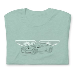 May include: A light blue t-shirt with a white outline of an Aston Martin car and wings with the text "ASTON MARTIN" above the car.