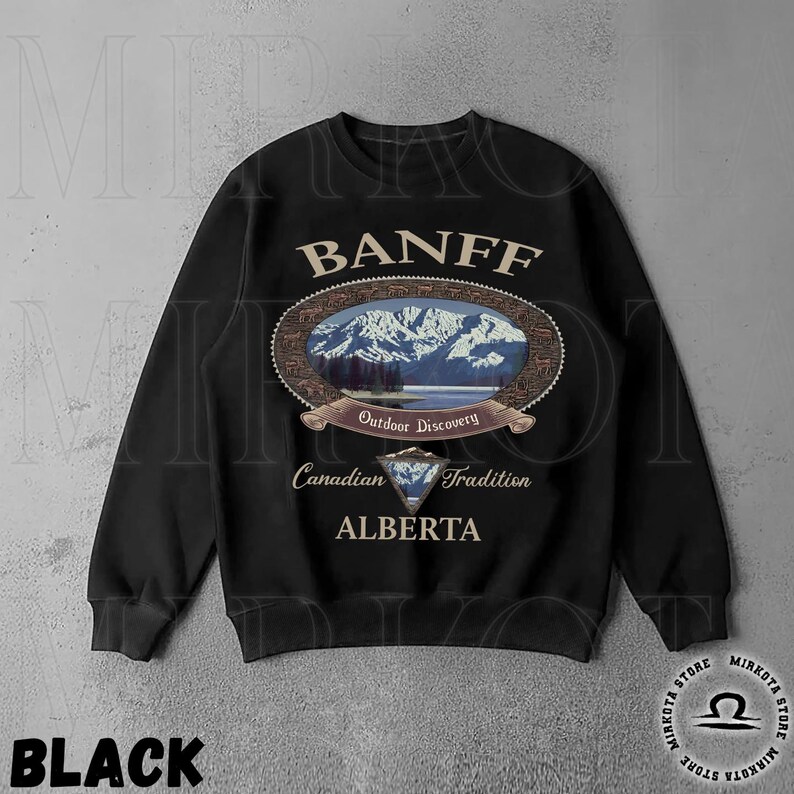 May include: Black sweatshirt with a Banff, Alberta design. The design features an oval image of mountains and a lake, with text that reads "Outdoor Discovery" and "Canadian Tradition". The word "Banff" is arched across the top.