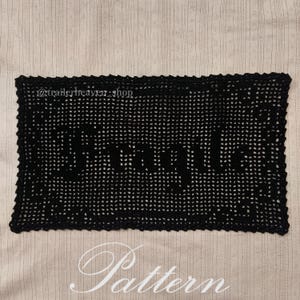 May include: Black crochet doily with the word "Remarkable" written in the centre. The doily is on a beige background with the word "Pattern" written below it. The text "@trailerheaven_shop" is in the top left corner of the doily.