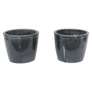 Può includere: Due vasi in ceramica grigio scuro con finitura smaltata. I vasi sono rotondi e hanno un bordo leggermente svasato.