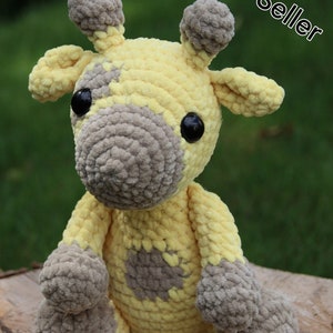 May include: A crocheted giraffe plush toy with yellow and gray fur. The giraffe has large black eyes and a sweet expression.