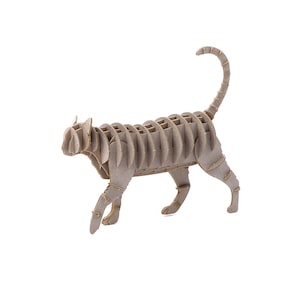 May include: A light brown cardboard cat sculpture, constructed from interlocking pieces. The cat is shown in a walking position, with its tail curved upwards. The design uses slotted, parallel pieces to create the cat's form. The sculpture is a decorative item.