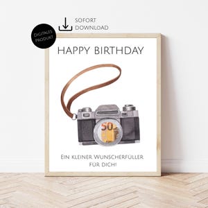 Könnte beinhalten: Ein gerahmter Druck mit der Aufschrift "HAPPY BIRTHDAY" über einer Aquarellillustration einer Vintage-Kamera. Die Kamera hat einen braunen Riemen und einen 50-Euro-Schein im Objektiv. Der Text "EIN KLEINER WUNSCHERFÜLLER FÜR DICH!" steht darunter.