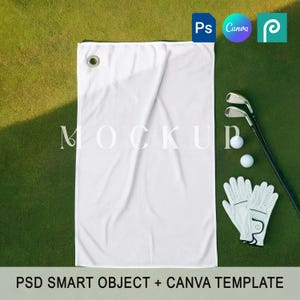 Op de afbeelding: Een witte golftowel met een grommet, golfclubs, golfballen en een paar witte golfhandschoenen op een groen oppervlak. De tekst "MOCKUP" staat op de handdoek. De tekst "PSD SMART OBJECT + CANVA TEMPLATE" staat onderaan.