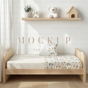 May include: A wooden toddler bed with a white and gray patterned sheet featuring a car design. The bed is against a white wall with a wooden shelf above it. The shelf has a small wooden house, a white teddy bear, and a white stuffed animal on it.