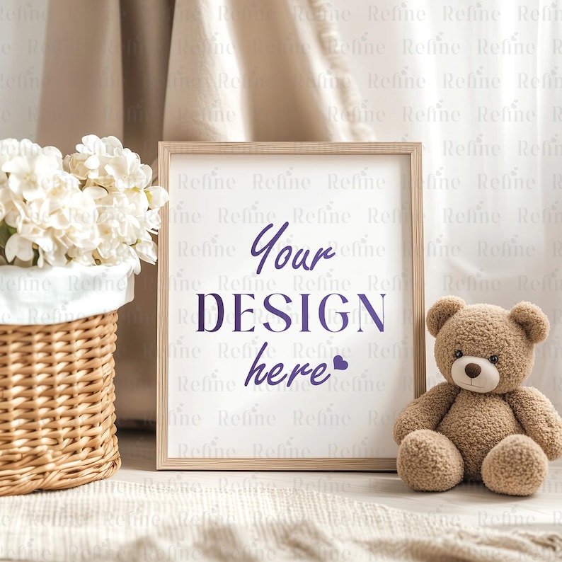 May include: A light wood frame with a white background and the text "Your DESIGN here" in purple. The frame is sitting on a white surface with a white wicker basket filled with white flowers and a brown teddy bear to the right.