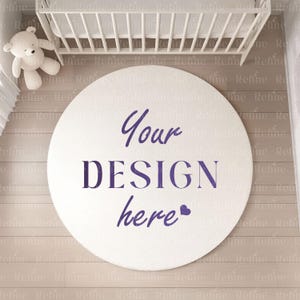 May include: A white round rug with the text "Your DESIGN here" in purple lettering. The rug is on a light brown wood floor in a nursery setting.