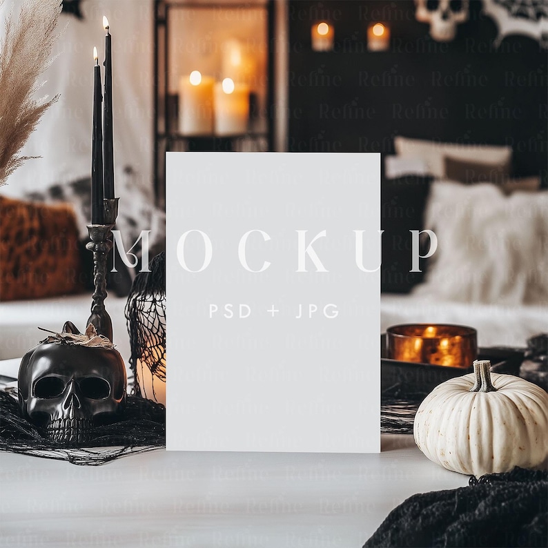 Op de afbeelding: Een Halloween-thema mockup met een blanco witte kaart met het woord "MOCKUP". De sc&egrave;ne bevat een zwarte schedel, kaarsen, een kleine witte pompoen en andere decoratieve elementen. De achtergrond is wazig.
