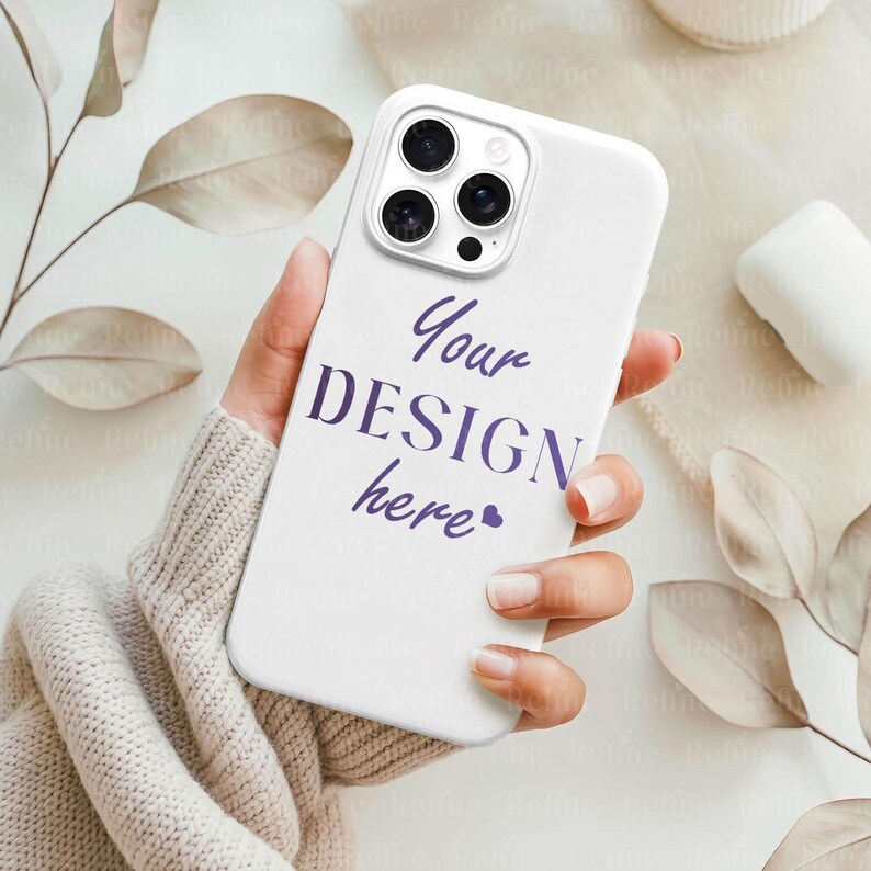 May include: A white phone case with a triple-lens camera design. The case features the text "Your DESIGN here" in purple script. The phone case is held in a person's hand.