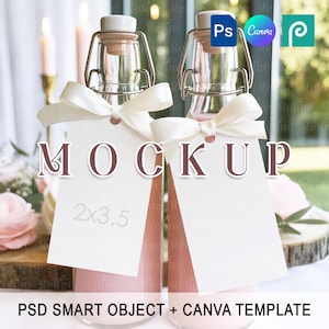 Può includere: Due bottiglie di vetro con chiusure a leva, riempite con un liquido rosa, sono decorate con etichette e fiocchi bianchi. Le etichette recitano "MOCKUP" e "2x3.5". L'immagine è un mockup, con il testo "PSD SMART OBJECT + CANVA TEMPLATE" in basso.