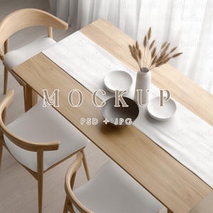 Puede incluir: Una mesa de madera con dos sillas, un mantel blanco y un jarrón con flores secas. Hay tres platos y un tazón en la mesa. El texto "MOCKUP PSD + JPG" está impreso en la mesa.