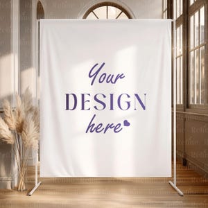 May include: A white backdrop with the text "Your DESIGN here" in purple script. The backdrop is supported by a white metal frame. The scene is set in a room with a wooden floor and tall windows.