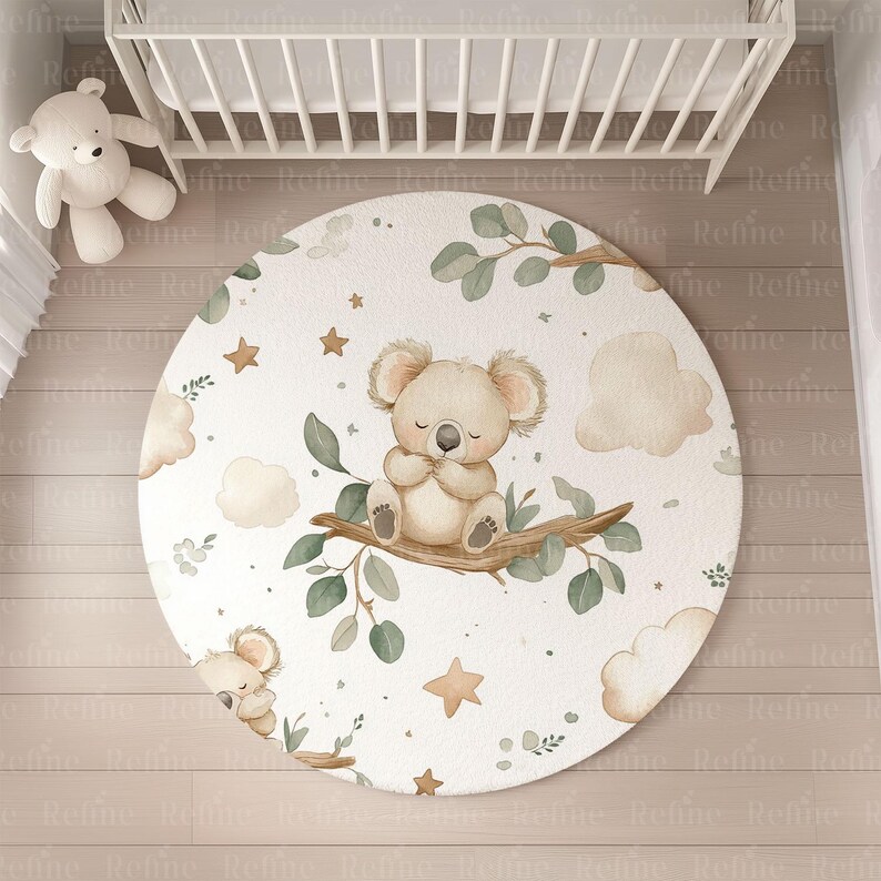 May include: A white round play mat with a koala bear design. The koala is brown and sitting on a branch with green leaves. The mat has a white background with brown clouds and stars.
