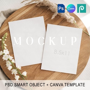 May include: Two white rectangular mockups with the word "MOCKUP" printed on one, and "8.5x11" on the other. The mockups are on a wooden tray with dried plants and white flowers. The text "PSD SMART OBJECT + CANVA TEMPLATE" is at the bottom.