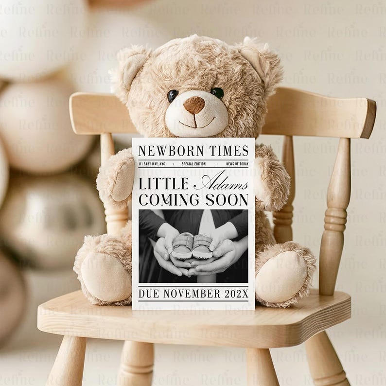 Peut inclure: Un ours en peluche beige est assis sur une chaise en bois, tenant une annonce de style journal. L'annonce indique "NEWBORN TIMES" et "LITTLE Adams COMING SOON" avec une photo de chaussures de b&eacute;b&eacute;. Le texte "DUE NOVEMBER 202X" est &eacute;galement visible.