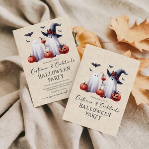 May include: Two Halloween party invitations with watercolor illustrations. The cards feature ghosts, pumpkins, bats, and text that reads "Costumes & Cocktails Halloween Party". The invitations are on a beige background.