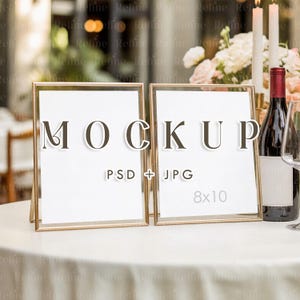 Pode incluir: Duas maquetes com moldura dourada com inserções brancas, exibindo a palavra "MOCKUP" em letras grandes. As molduras estão sobre uma toalha de mesa branca, com uma garrafa de vinho, velas e flores ao fundo. O texto "PSD + JPG" e "8x10" também são visíveis.