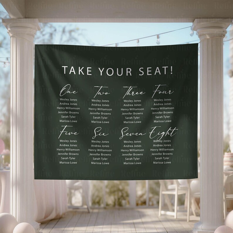 May include: A dark green wedding seating chart banner with white calligraphy text that reads "TAKE YOUR SEAT!" and lists names under numbers one through eight. The banner is hanging outdoors.