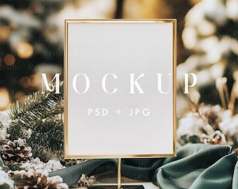 May include: A gold-framed mockup sign with a white background and the text "MOCKUP PSD + JPG" on a table with green fabric and pine branches.