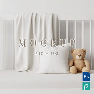 Puede incluir: Una escena de maqueta con una almohada blanca, un oso de peluche beige y una manta blanca sobre una cuna. La palabra "MOCKUP" se muestra, con "PSD + JPG" debajo. Un icono de Photoshop está en la esquina inferior derecha.