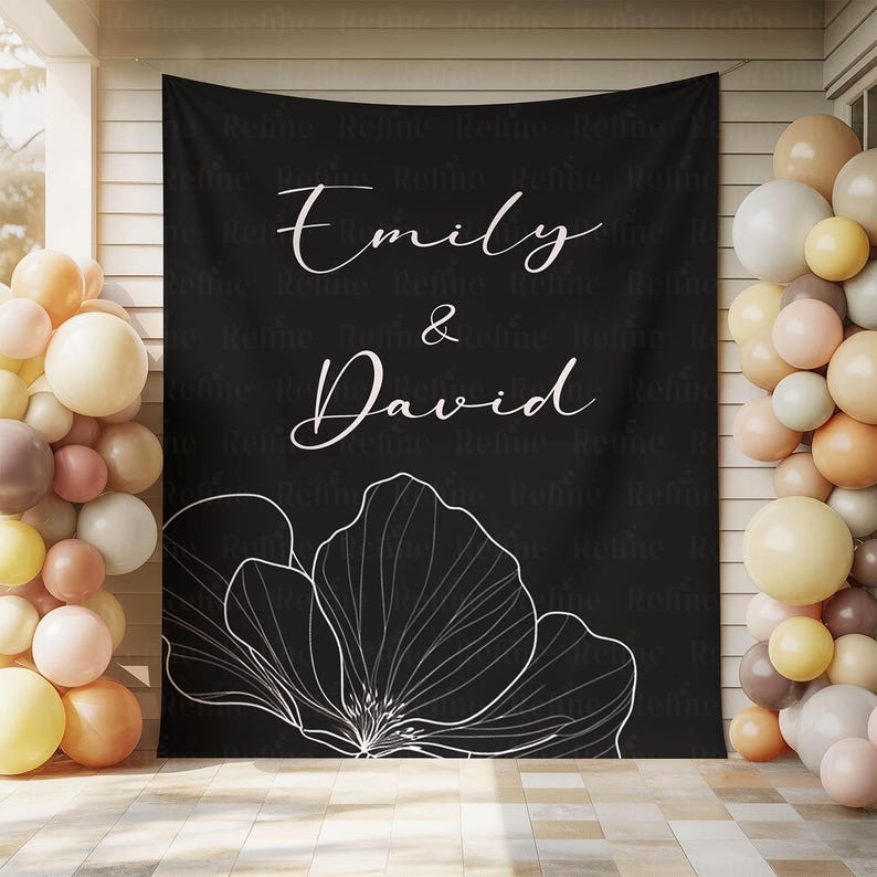 K&ouml;nnte beinhalten: Schwarzer Hintergrund mit wei&szlig;em Blumendesign und den Namen "Emily & David" in eleganter Schrift. Die Szene ist mit Luftballons in Creme-, Pfirsich- und Braunt&ouml;nen dekoriert, ideal f&uuml;r eine Hochzeits- oder Verlobungsfeier. Der Hintergrund ist an einer Wand befestigt.