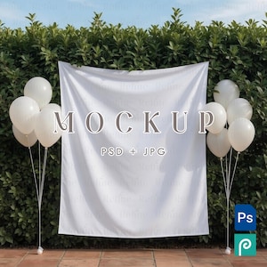 May include: A white backdrop with the word "MOCKUP" in brown letters, with "PSD + JPG" below. White balloons are on either side of the backdrop. The backdrop is in front of a green hedge. The sky is blue.