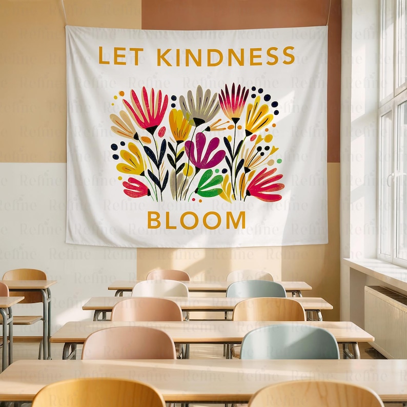 May include: White wall tapestry with the words "LET KINDNESS BLOOM" in gold lettering. The tapestry features a colorful floral design with red, yellow, purple, and green flowers. The tapestry is hanging in a classroom.