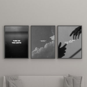 May include: Three black and white framed prints with inspirational quotes. The first print features a starry night sky with the text "Turn on the lights". The second print features a cloudy sky with the text "I adore u". The third print features a hand reaching out with the text "Pull me out of this".