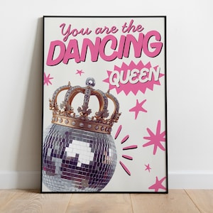 Może przedstawiać: Oprawiony wydruk z napisem "You are the DANCING QUEEN" w kolorze różowym. Pod tekstem znajduje się kula dyskotekowa ze złotą koroną, z różowymi rozbłyskami i gwiazdami na białym tle.