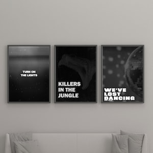 May include: Three framed black and white art prints. The first print reads "TURN ON THE LIGHTS". The second print features a snake and reads "KILLERS IN THE JUNGLE". The third print shows a disco ball and reads "WE'VE LOST DANCING".