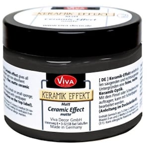 Könnte beinhalten: Ein schwarzes Glas Keramik Effekt Matt Keramik-Effekt-Farbe von Viva Decor. Das Glas hat einen schwarzen Deckel und ein gold-weißes Etikett. Der Text "Ceramic Effect matte" ist ebenfalls sichtbar. Hergestellt in Deutschland.