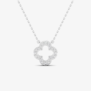 May include: A silver necklace with a four-leaf clover pendant encrusted with small diamonds.