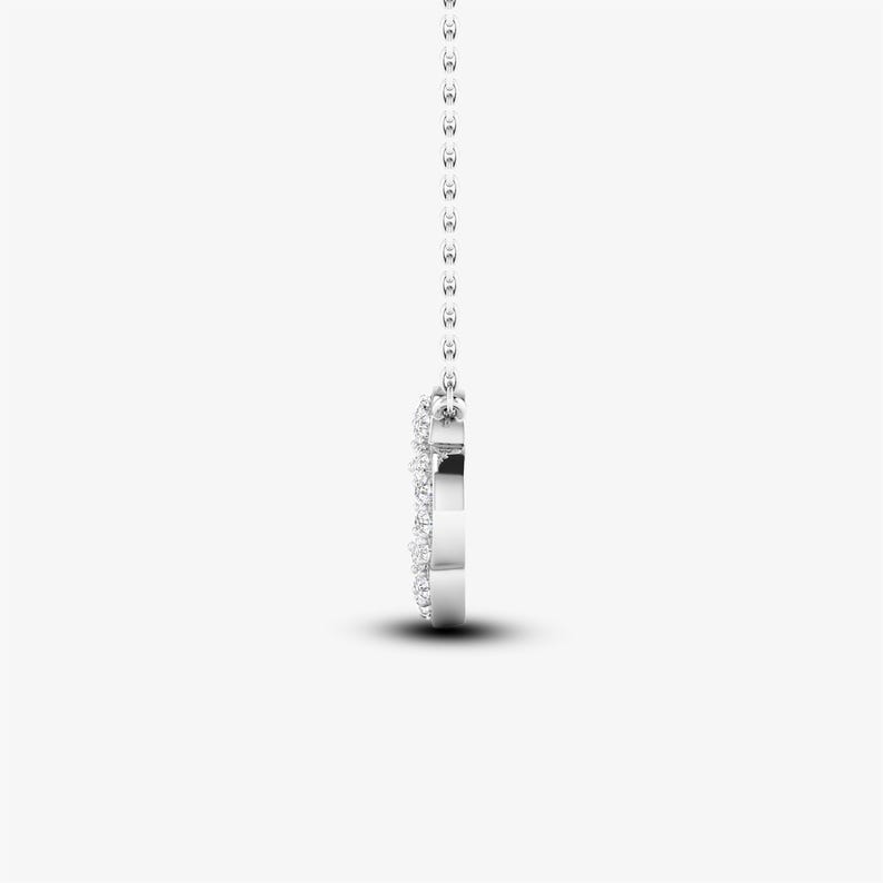 May include: A silver necklace with a heart-shaped pendant that is encrusted with small diamonds.