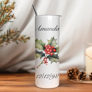 Puede incluir: Vaso blanco con un dise&ntilde;o de acebo y bayas. El nombre "Amanda" y la fecha "12/12/98" est&aacute;n impresos en el vaso. Una pajita de acero inoxidable est&aacute; insertada en la tapa. Es un art&iacute;culo con tem&aacute;tica navide&ntilde;a.