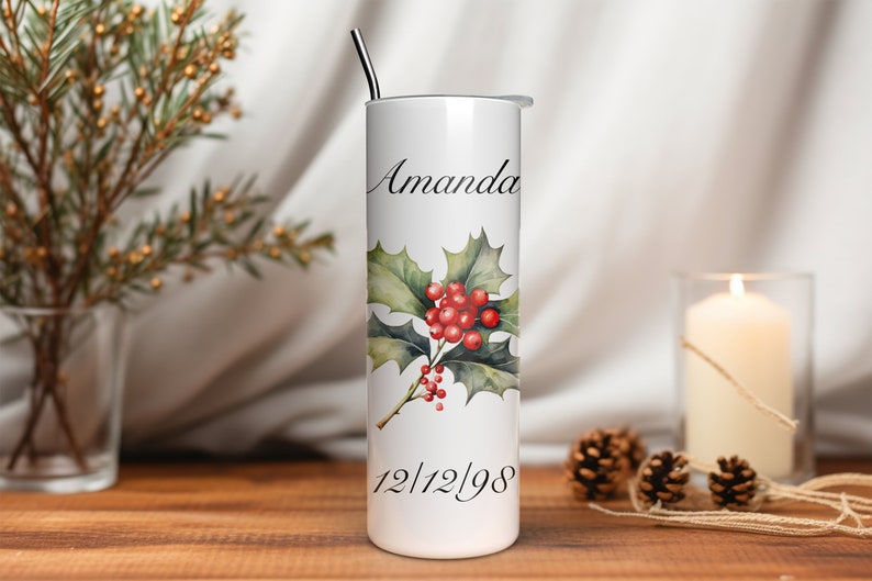 Puede incluir: Vaso blanco con un dise&ntilde;o de acebo y bayas. El nombre "Amanda" y la fecha "12/12/98" est&aacute;n impresos en el vaso. Una pajita de acero inoxidable est&aacute; insertada en la tapa. Es un art&iacute;culo con tem&aacute;tica navide&ntilde;a.