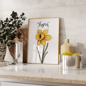 May include: A framed print with a yellow daffodil illustration and the word "March" in a decorative font.
