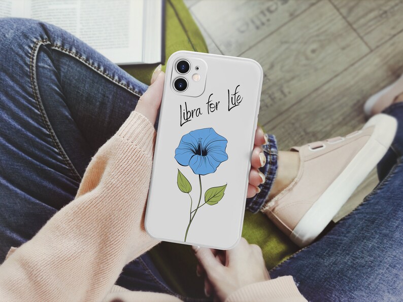 May include: A white phone case with a blue flower and the text "Libra for Life" printed on it.