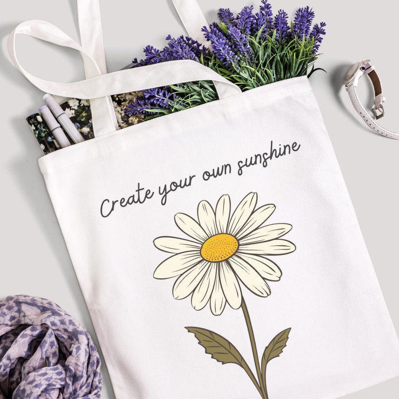 May include: White canvas tote bag with a daisy and the text "Create your own sunshine".