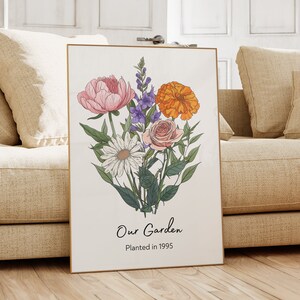 Puede incluir: Una impresi&oacute;n enmarcada con un ramo de flores en tonos rosa, morado, naranja y blanco. El texto "Our Garden Planted in 1995" est&aacute; en la parte inferior de la impresi&oacute;n.